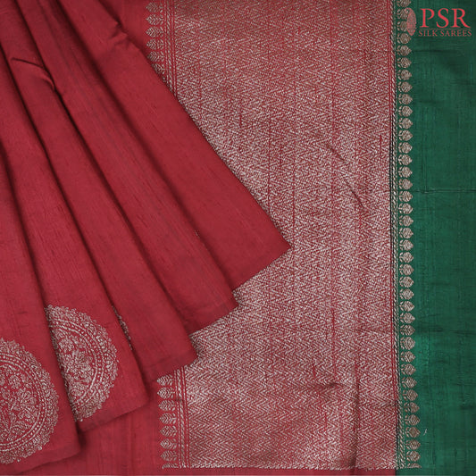 PSR Silks unveils a magnificent Berry Red Banaras Jute Silk Saree, beautifully paired with a luxurious Dark Green combination. 