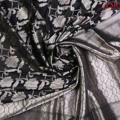 PSR Silks presents a charming Black Banarasi Silk Saree, featuring a beautifully woven floral ogee jacquard pattern crafted with exquisite silver zari.