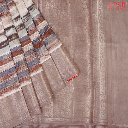 Presenting a Soft Chiniya Silk Saree in a graceful Dusty Mauve hue, designed to captivate and charm. This exquisite saree features brush stripes complemented by intricate zari brocade motifs, adding a modern twist to traditional beauty.