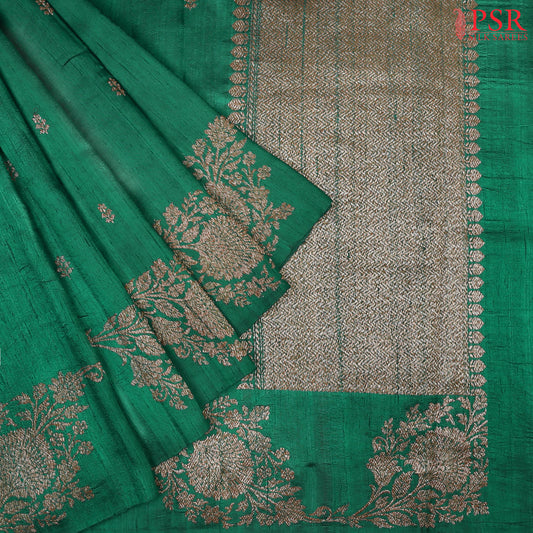 PSR Silks presents a stunning Emerald Green&nbsp;Banaras Jute Silk Saree, paired beautifully with a rich Berry Red combination.