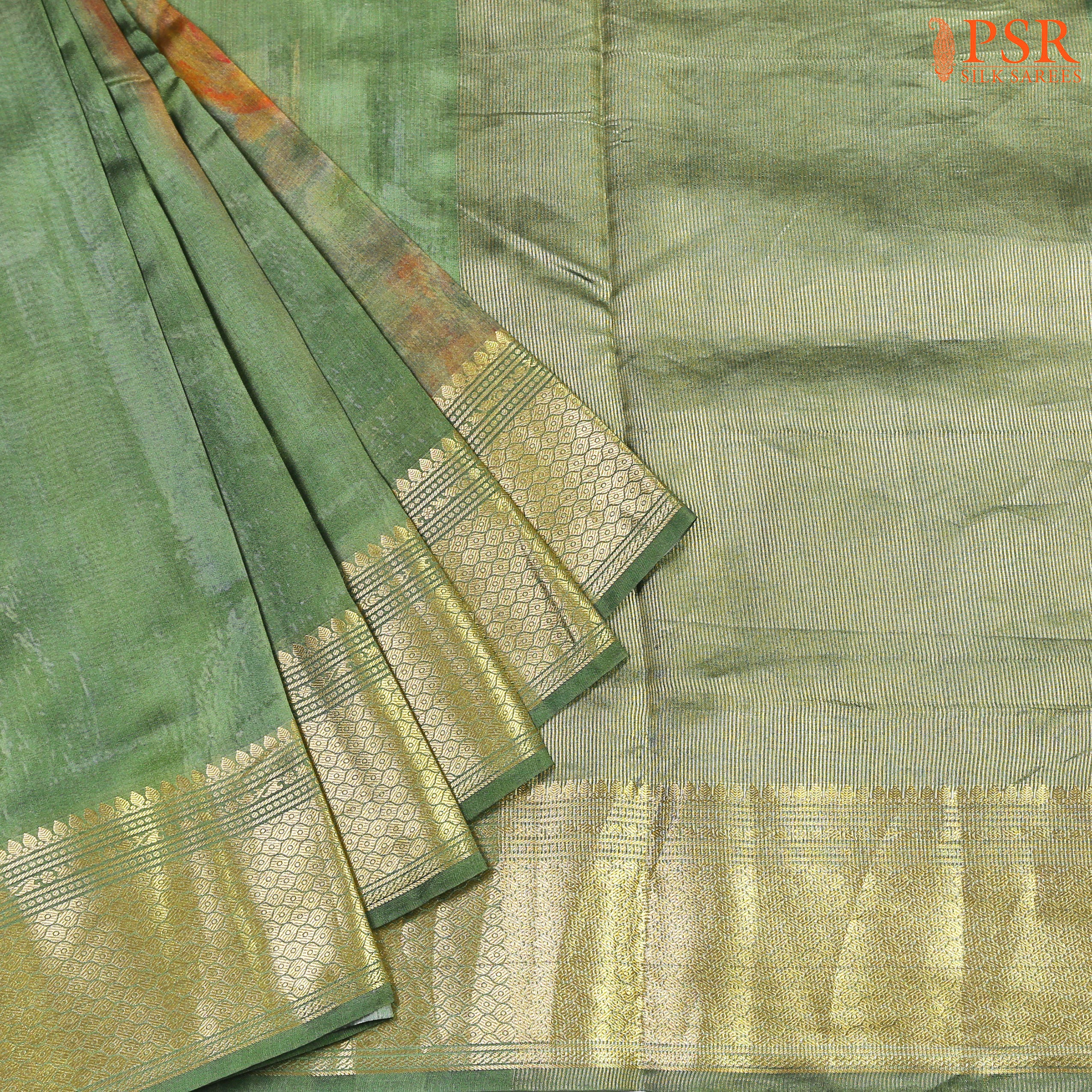 PSR Silks proudly presents an exquisite Fern Green Chiniya Silk saree that exudes elegance and charm. This stunning saree showcases double-shaded, vibrantly dyed floral prints,