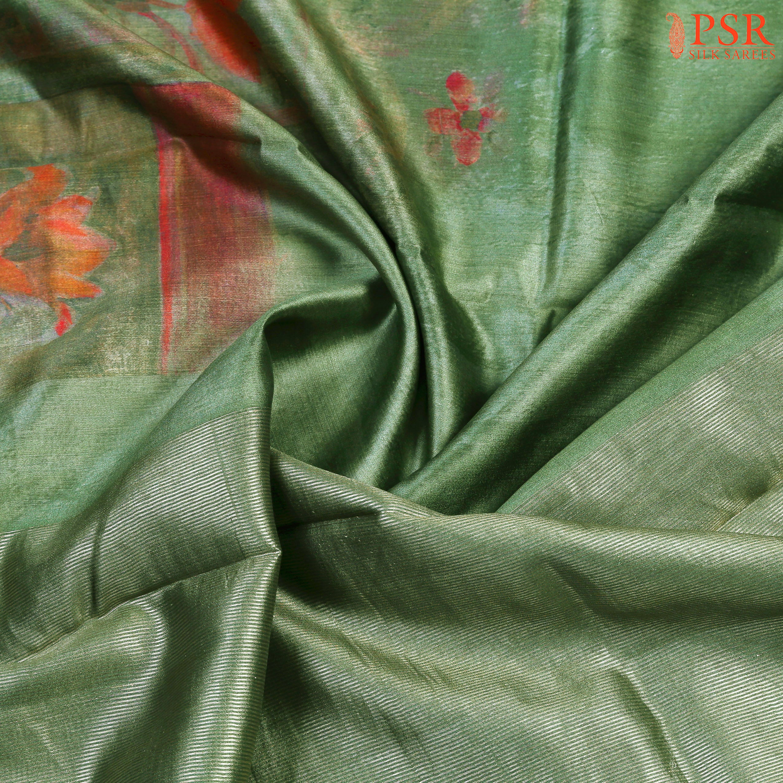 PSR Silks proudly presents an exquisite Fern Green Chiniya Silk saree that exudes elegance and charm. This stunning saree showcases double-shaded, vibrantly dyed floral prints