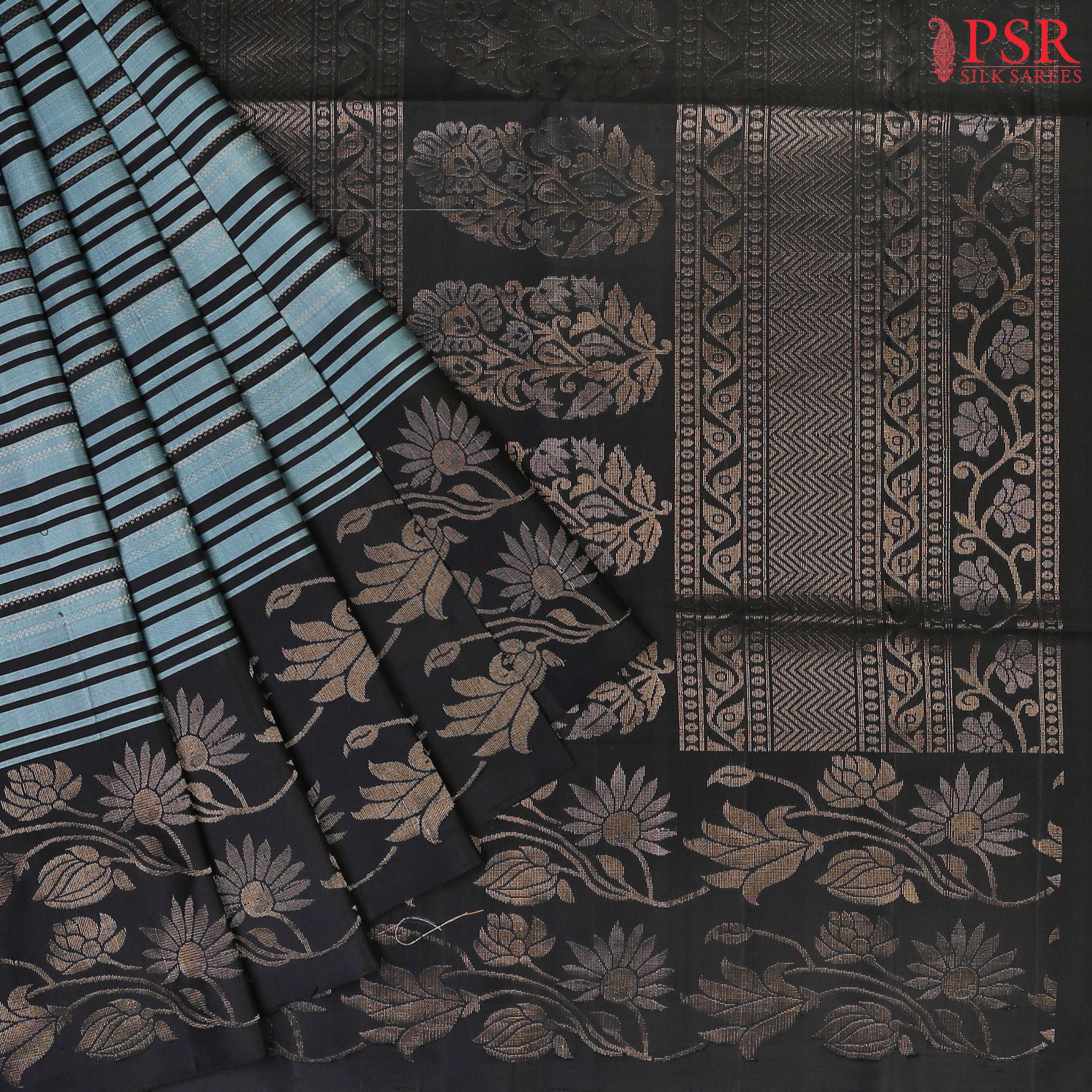 Presenting the exquisite French Moire Blue Soft Silk Saree, perfectly paired with the timeless elegance of Black. This stunning saree showcases a chic horizontal striped pattern, beautifully enriched with intricate zari work, adding a touch of opulence to your look.