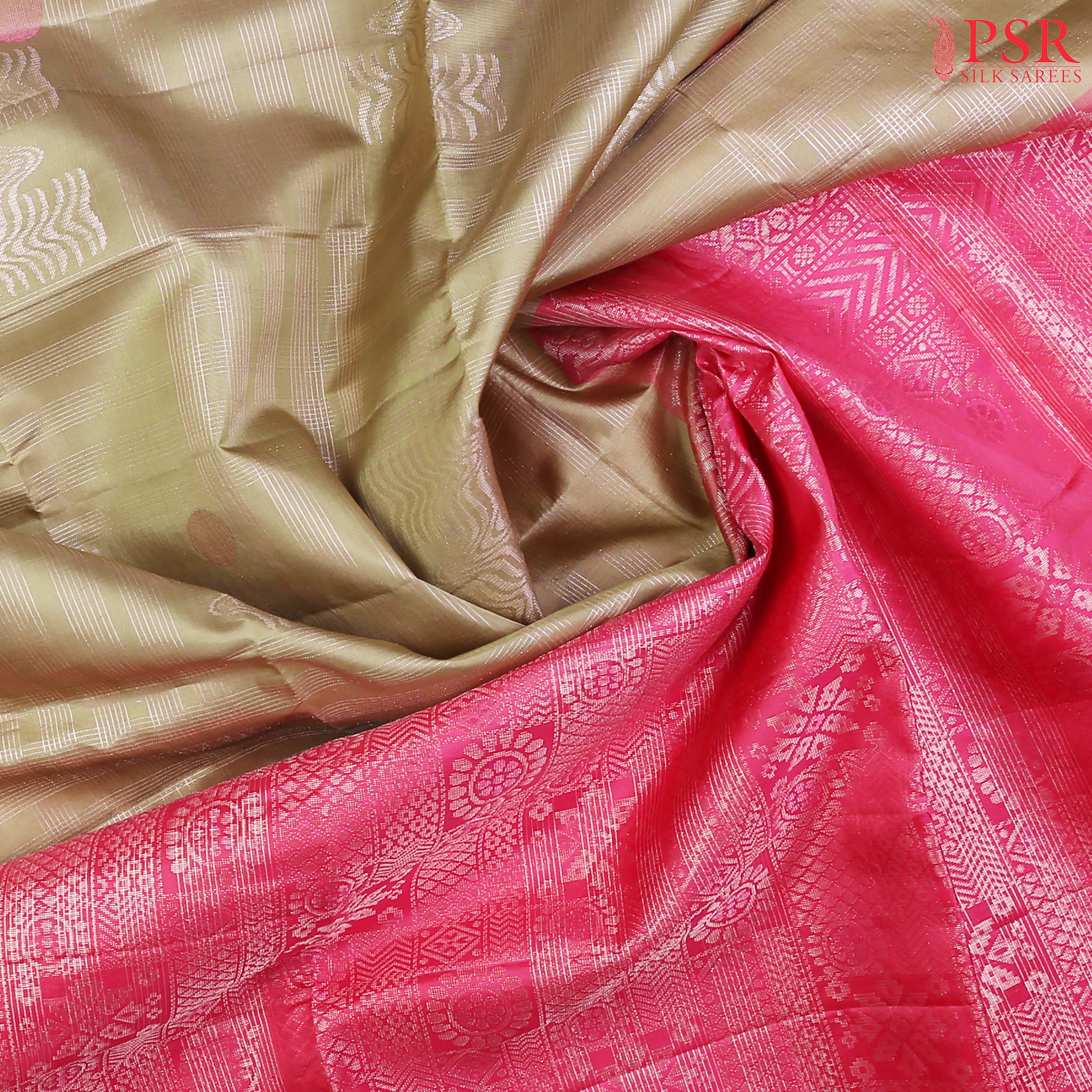 Drape yourself in contemporary grace with our Olive Mist Soft Silk Saree, beautifully contrasted with a vibrant Pink hue.