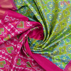 This Parrot Green &amp; Magenta Pink Pochampally Silk Saree from PSR Silk Sarees is a stunning embodiment of heritage and vibrance.