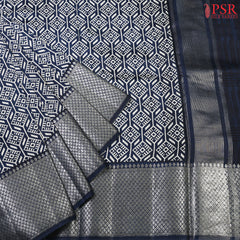 PSR Silks presents a delightful Navy Blue Chiniya Silk saree, exuding elegance and grace. This timeless piece features an elegantly designed hexagon tessellation pattern, adding a touch of tradition and charm to its allure.