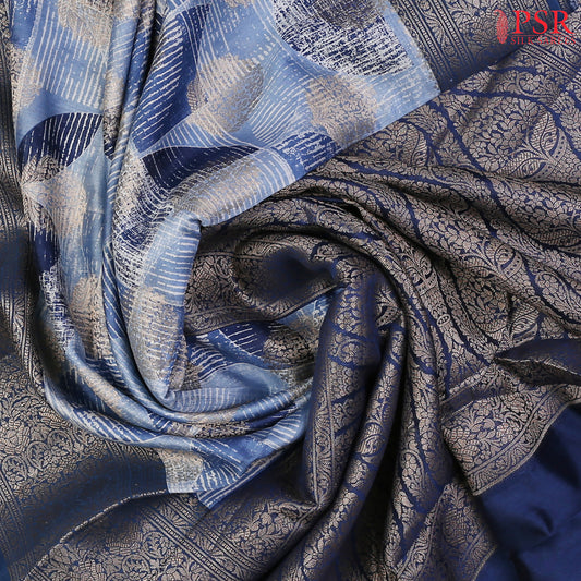 Drape yourself in sophisticated charm with our Steel Blue Chiniya Silk Saree, beautifully paired with Prussian Blue for a royal touch.