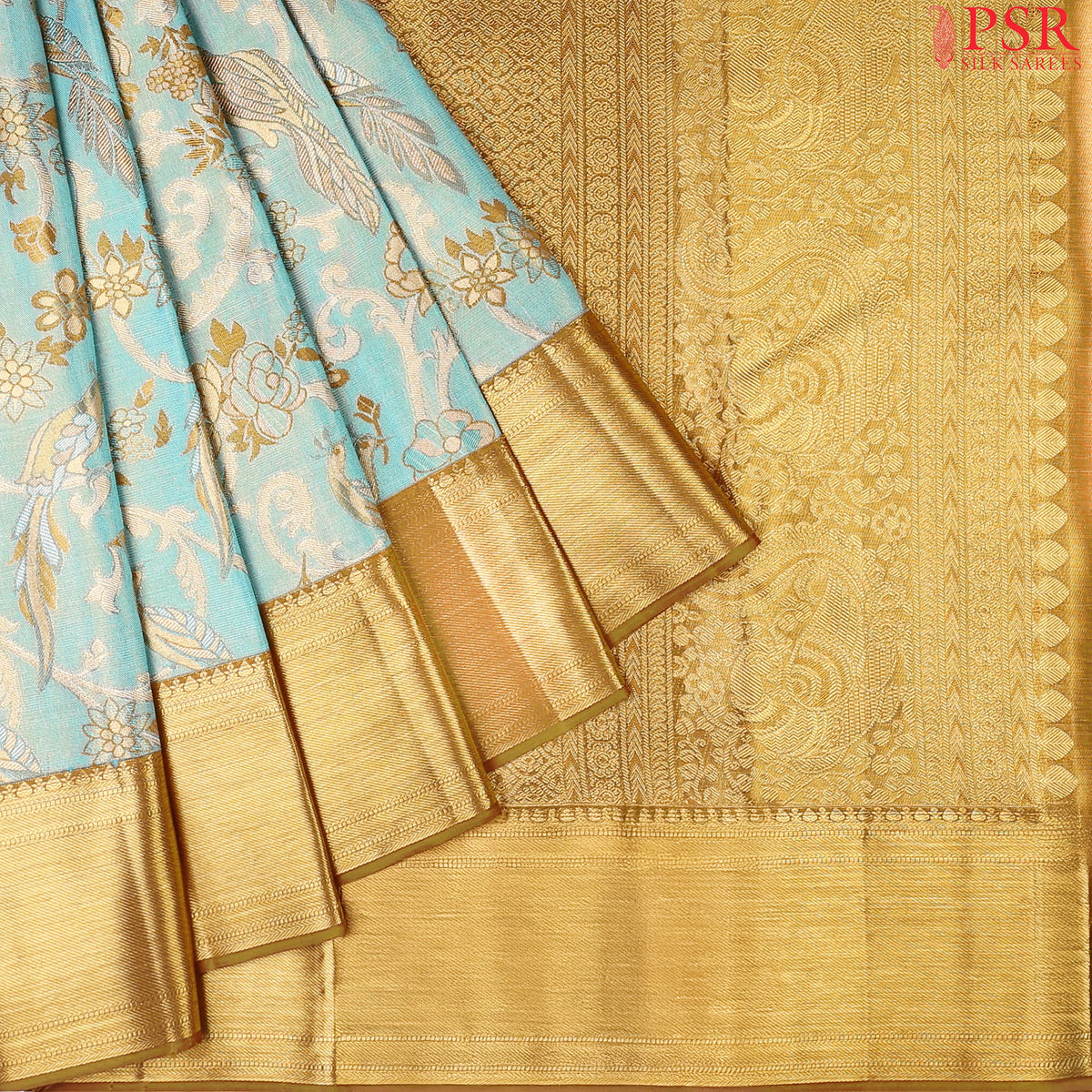 Turquoise Blue Kanchipuram Tissue Silk Saree with floral scroll zari weaves and bird motifs, paired with a Dark Mustard zari pallu, border, and tissue blouse.