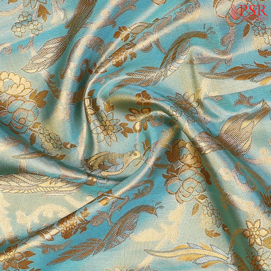 Turquoise Blue Kanchipuram Tissue Silk Saree with floral scroll zari weaves and bird motifs, paired with a Dark Mustard zari pallu, border, and tissue blouse.